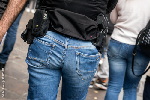 closeup of french criminality squad police with shotgun and handcuffs walking in the street