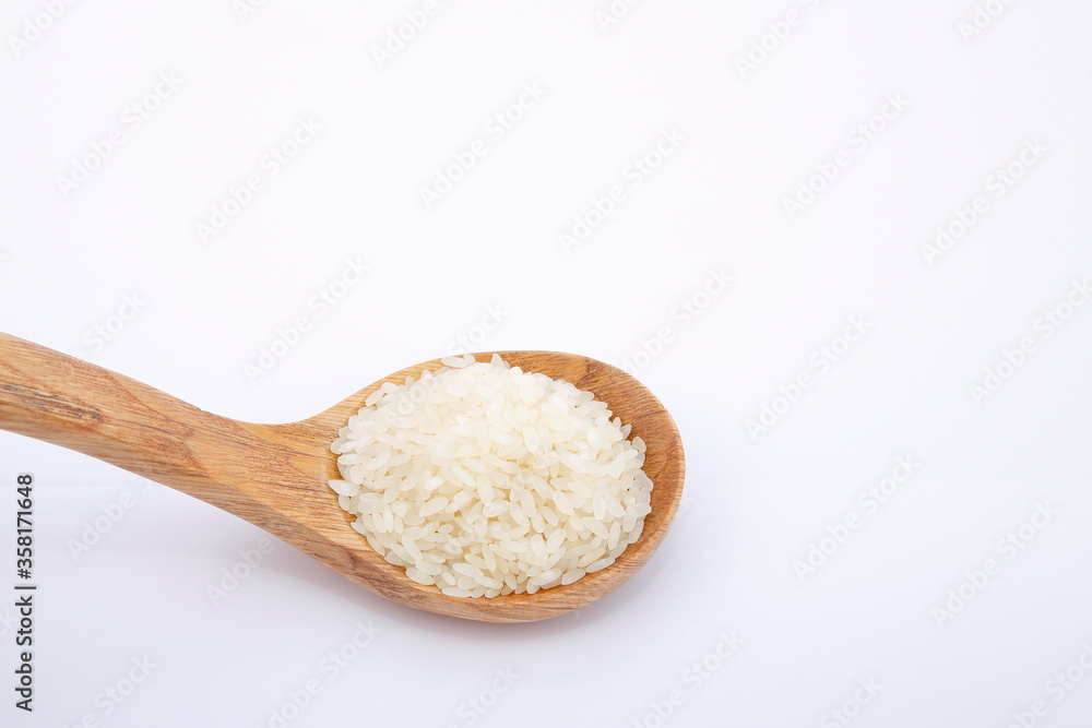 View of pile of rice in wooden spoon. View of pile of rice in wooden spoon.
