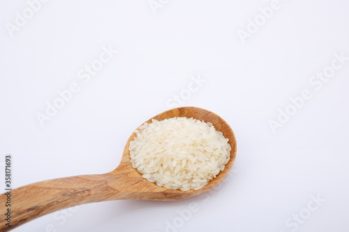 View of pile of rice in wooden spoon.