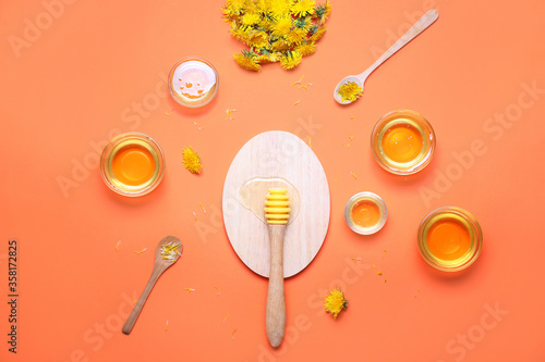 Tasty dandelion honey on color background photo