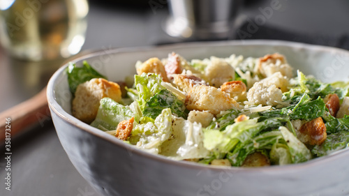 fresh caesar salad with croutons and parmasan cheese in bowl photo