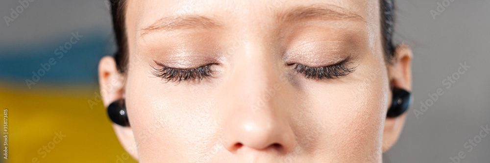 Obraz premium Close up portrait of attractive relaxed young woman meditating at home. Girl with eyes closed