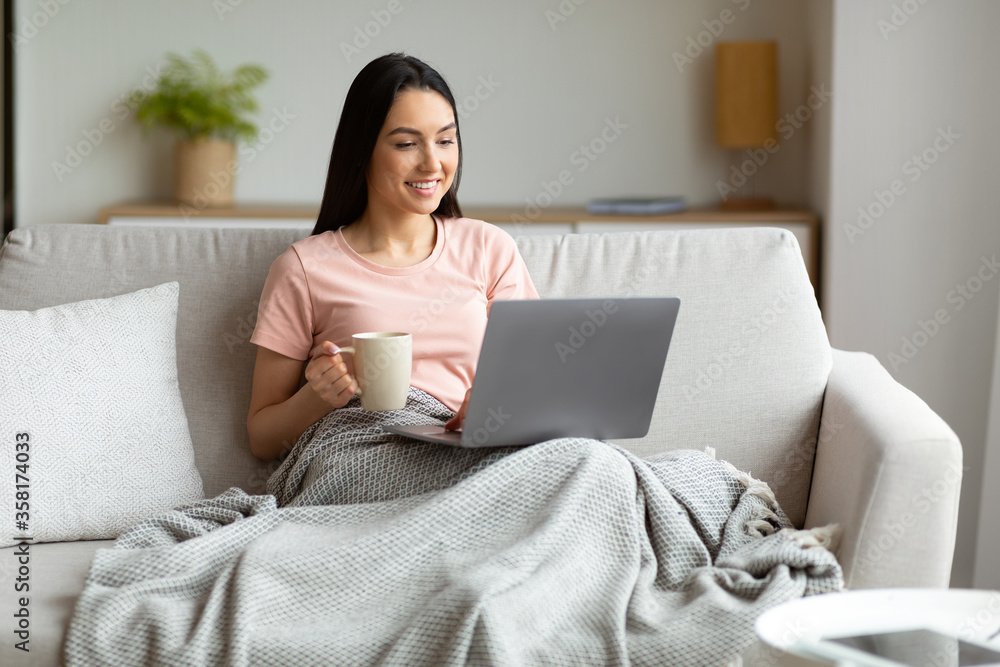 Woman With Laptop Having Coffee Sitting On Couch At Home Woman With Laptop Having Coffee Sitting On Couch At Home