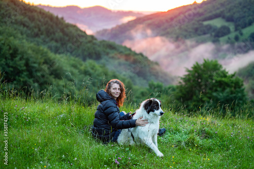 woman and dog in amazing summer landscape at sunset