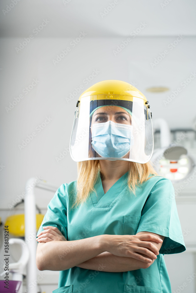 Mujer dentista con mascarilla y equipo de protección individual, EPI, garantizando la máxima seguridad para los pacientes en contra del coronavirus COVID-19 Mujer dentista con mascarilla y equipo de protección individual, EPI, garantizando la máxima seguridad para los pacientes en contra del coronavirus COVID-19