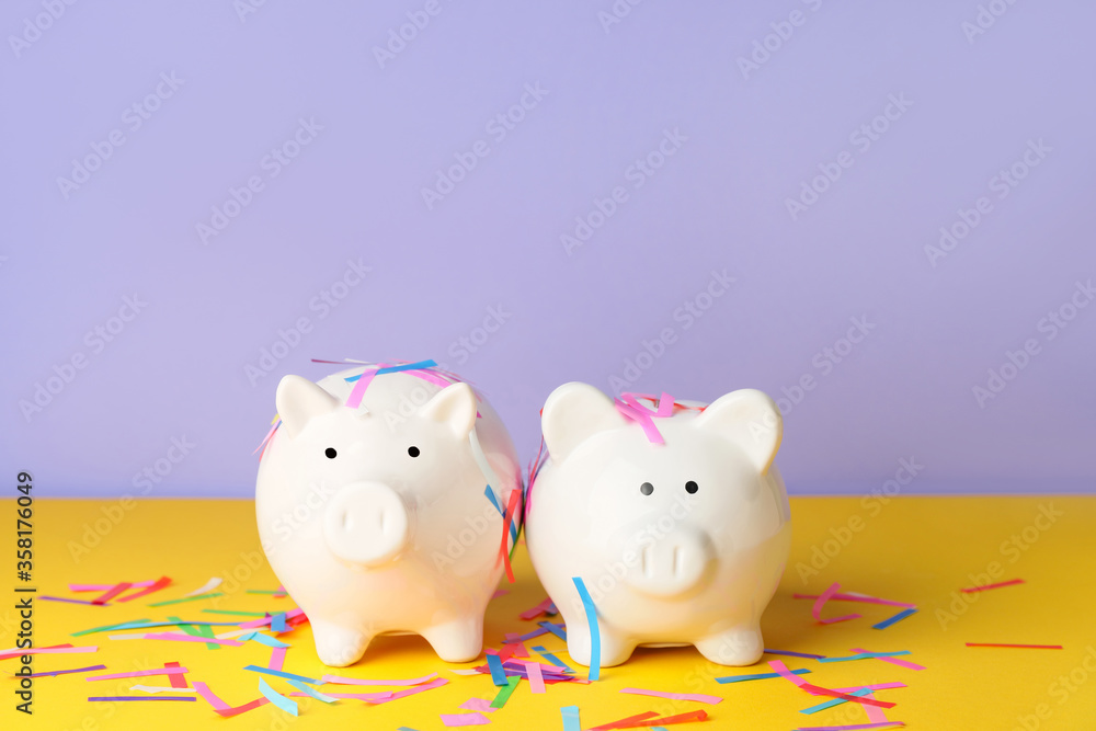 Piggy banks and confetti on color background Piggy banks and confetti on color background