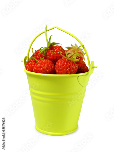 Small yellow metal bucket with wild strawberries isolated on white background      