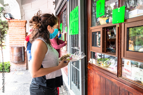Alvaro Obregon, CDMX. Mexico. June 10, 2020. Woman buys cookies with surgical mask for the new normal. photo
