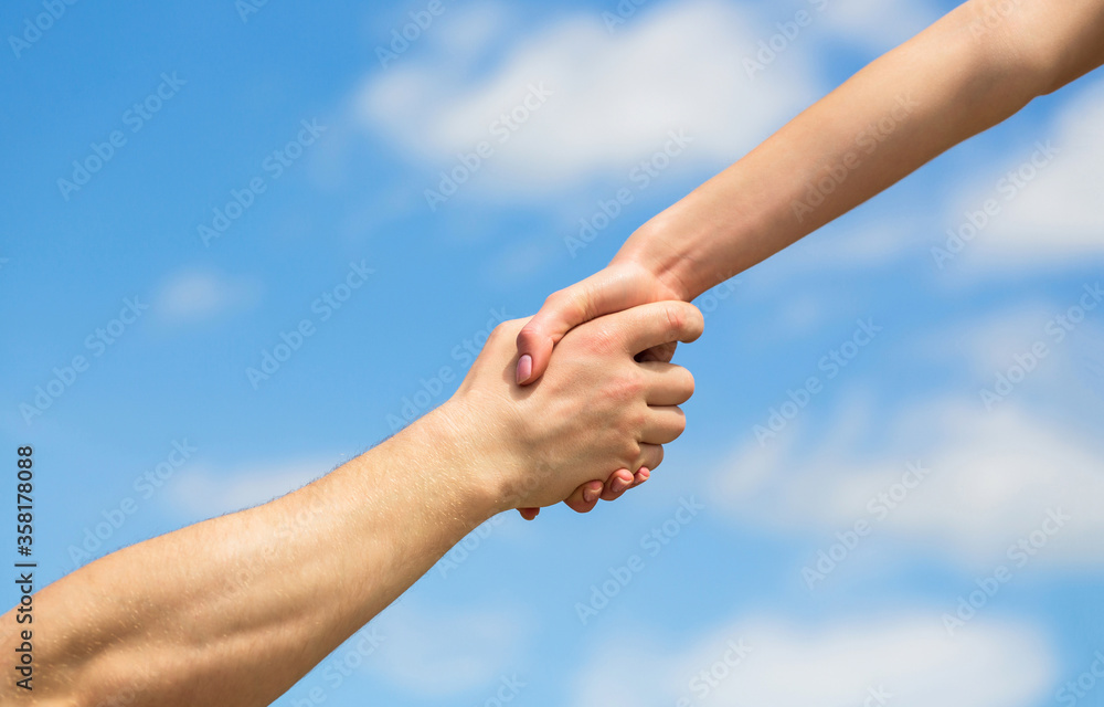Hands of man and woman reaching to each other, support. Giving a helping hand. Lending a helping hand. Solidarity, compassion, and charity, rescue. Hands of man and woman on blue sky background