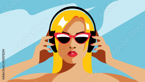 Blonde with headphones. Beautiful girl listening to music. Blue clear sky on the background.