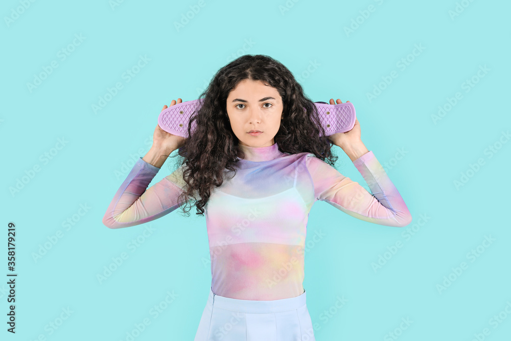 Beautiful young woman with skateboard on color background Beautiful young woman with skateboard on color background