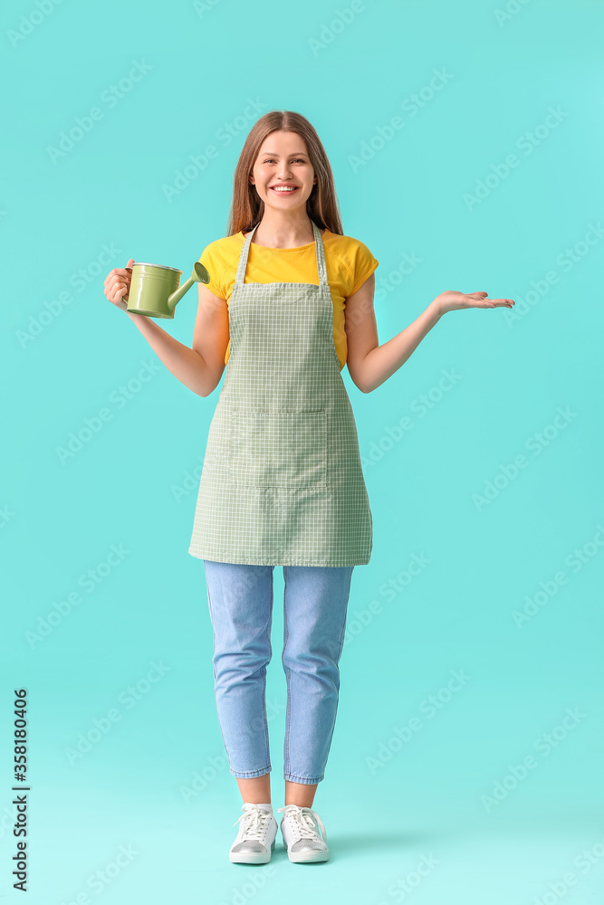Young woman with watering can on color background Young woman with watering can on color background