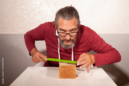 elderly man with bread at table