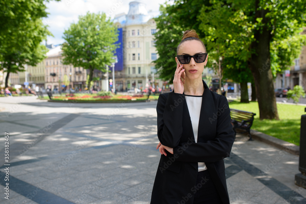 Young woman talking on a cell phone while walking around the city