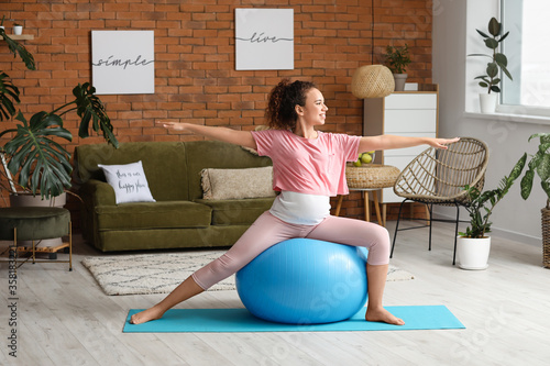 Young pregnant woman practi...