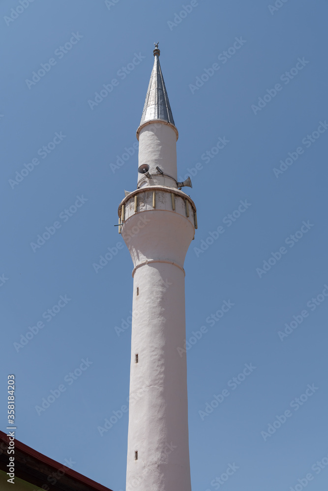 Detail of one white minaret with blue sky background Detail of one white minaret with blue sky background
