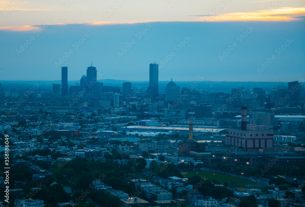 City of Boston, Massachusetts, United States of America at sunset, photo taken at sunset, some buildings are visible on the horizon.