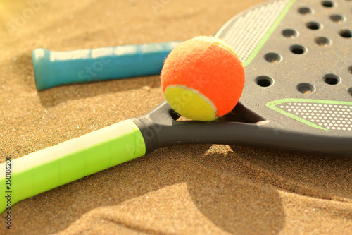 Beach tennis rackets in sand, summer beach sport  photo