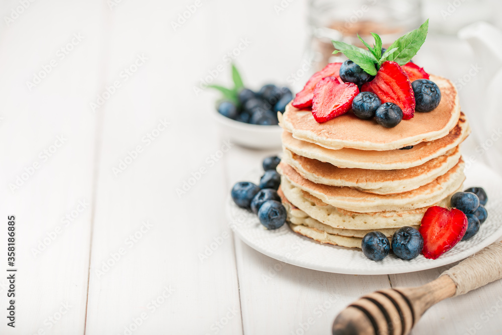 Classic american pancakes with fresh berry on white wood background. Summer homemade breakfast. Classic american pancakes with fresh berry on white wood background. Summer homemade breakfast.