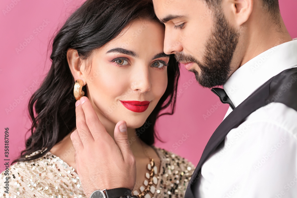 Naklejka premium Young couple wearing stylish accessories on color background