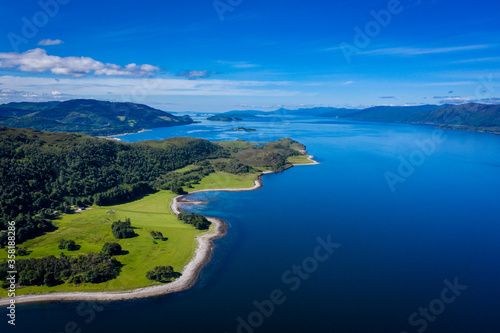 Fototapeta Naklejka Na Ścianę i Meble -  aerial image of loch linnhe on the west coast of the argyll and lochaber region of scotland near kentallen and duror showing calm blue waters and clear skies with green forest coast line