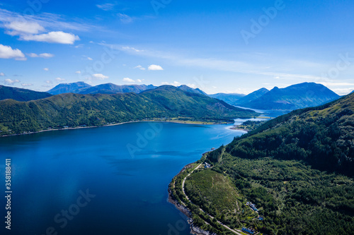 aerial image of the entrance to glencoe, ballachulish and loch leven from loch linnhe on the west coast of the argyll and lochaber region of the highlands of scotland on a clear blue sky summer day © Andy Morehouse