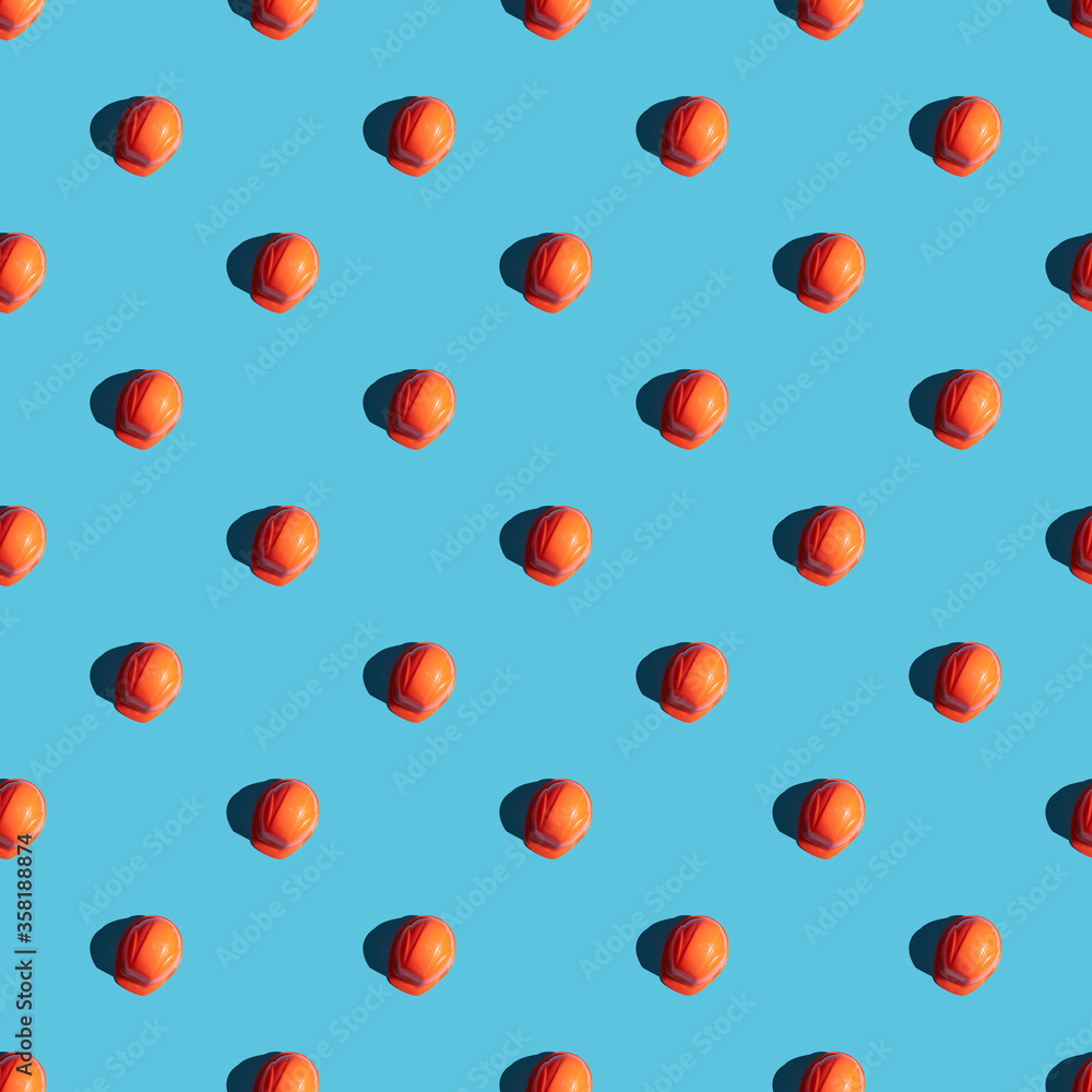 orange safety helmet seamless pattern on a blue background with hard shadows. looking from above. industrial contractor concept. orange safety helmet seamless pattern on a blue background with hard shadows. looking from above. industrial contractor concept.