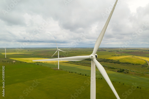 Aerial view of wind turbines in field on cloudy day