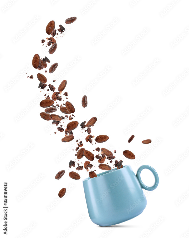 Obraz premium Cocoa beans falling into cup on white background