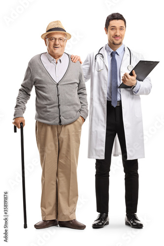 Full length portrait male doctor holding an elderly male patient with a walking cane on the shoulder