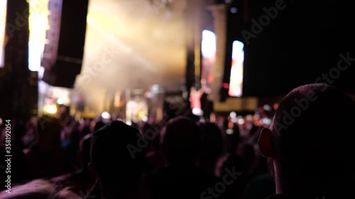 Defocused entertainment concert lighting on stage.Blurred Music Festival . Laser show on the stage. The crowd of fans.