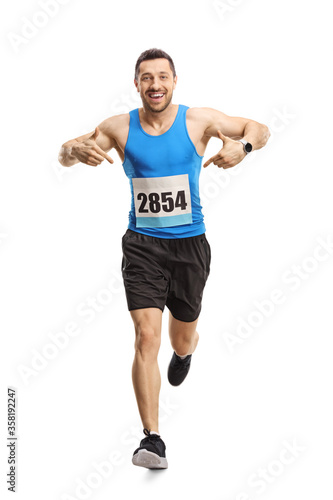 Male athlete running and pointing at his race number