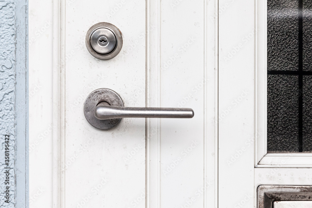 Entrance door handle close up. Lock and handle on the door. Reinforced door lock. Doorknob at a white door