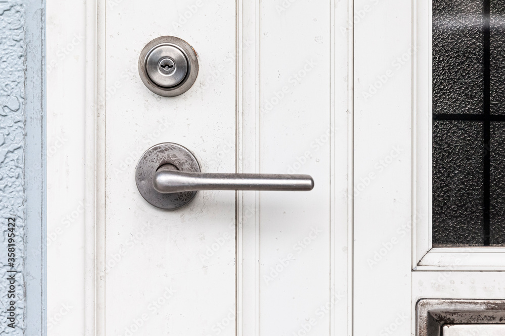Entrance door handle close up. Lock and handle on the door. Reinforced door lock. Doorknob at a white door Entrance door handle close up. Lock and handle on the door. Reinforced door lock. Doorknob at a white door