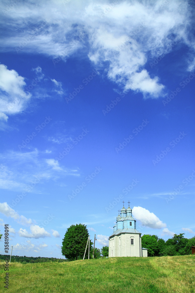 Church on a hill on the outskirts of the village. Christian temple landscape in Russia. Stock photo background Church on a hill on the outskirts of the village. Christian temple landscape in Russia. Stock photo background