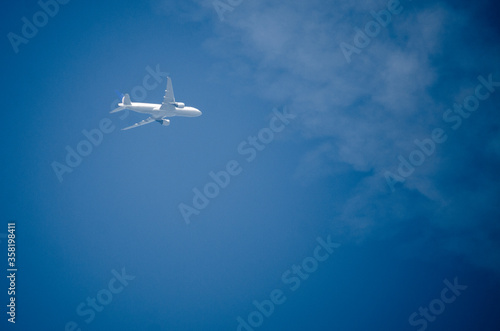 Airplane flying across a blue sky.