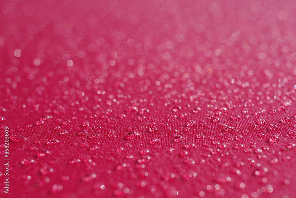 Close-up full frame macro view with selected focus on water drops from morning fog on the red fabric of an umbrella Close-up full frame macro view with selected focus on water drops from morning fog on the red fabric of an umbrella