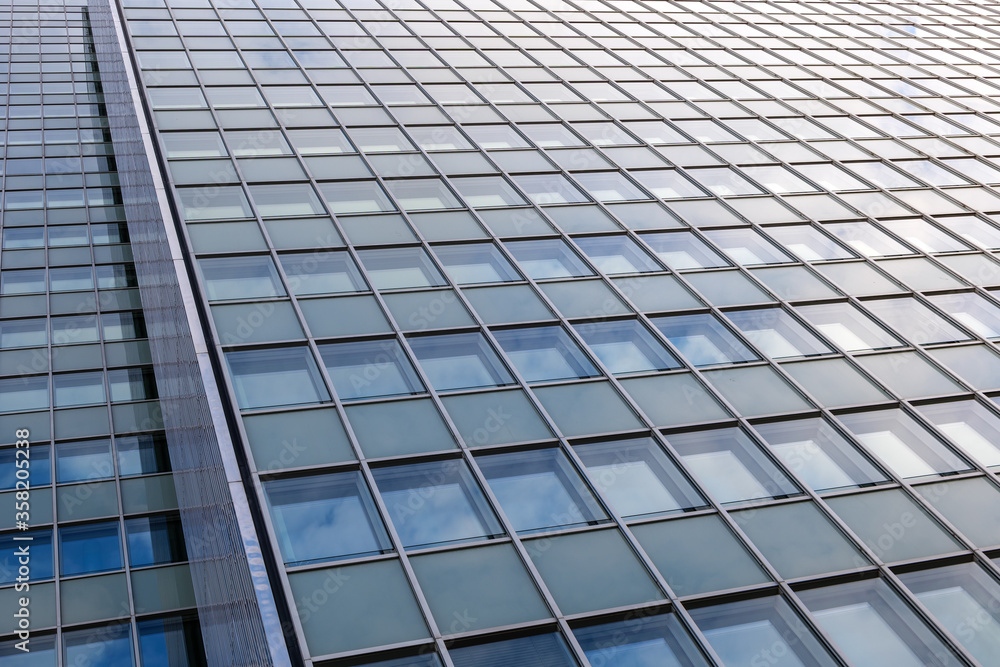 Close up detail of reflected glass facade with rectangular windows grid frame system of modern office building. Abstract Architectural Geometry elements background with urban metropolis concept. Close up detail of reflected glass facade with rectangular windows grid frame system of modern office building. Abstract Architectural Geometry elements background with urban metropolis concept.