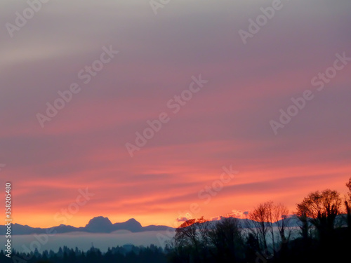 Sunrise over Cascade Mountain Range in Washington State with violet, orange, and yellow sky. © Ute Sonja Medley