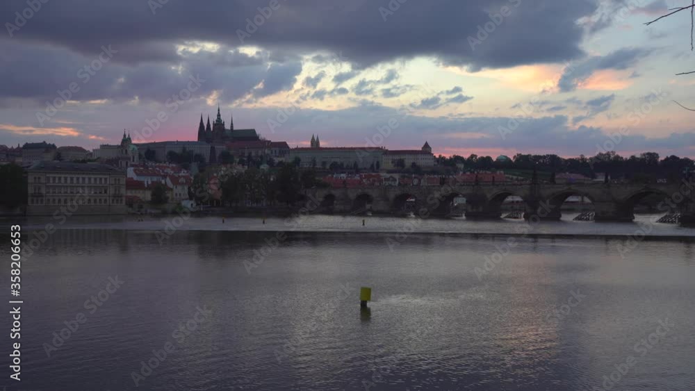 Charles Bridge, Prague Castle, St. Vitus Cathedral and the flowing Vltava River and the roofs of buildings at sunset in the center of Prague in the Czech Republic in summer Charles Bridge, Prague Castle, St. Vitus Cathedral and the flowing Vltava River and the roofs of buildings at sunset in the center of Prague in the Czech Republic in summer