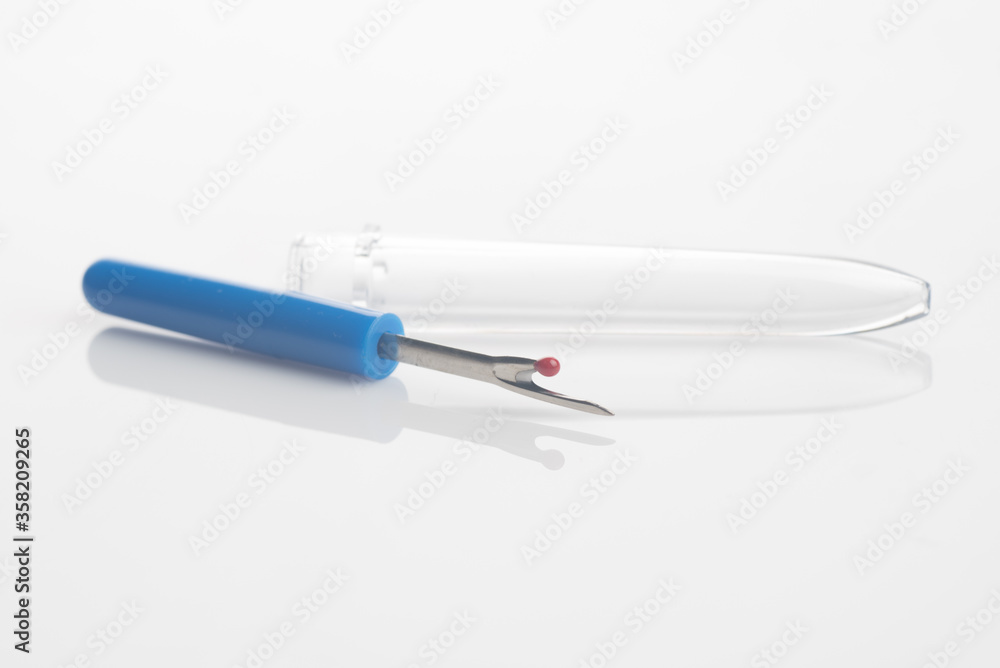 seam ripper isolated over white reflective background seam ripper isolated over white reflective background
