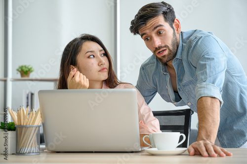 Happy and relax lifestyle of young couple lover wearing casual dress together working on laptop notebook computer in living room at home.