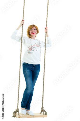 beautiful young woman on a swing against white studio background.