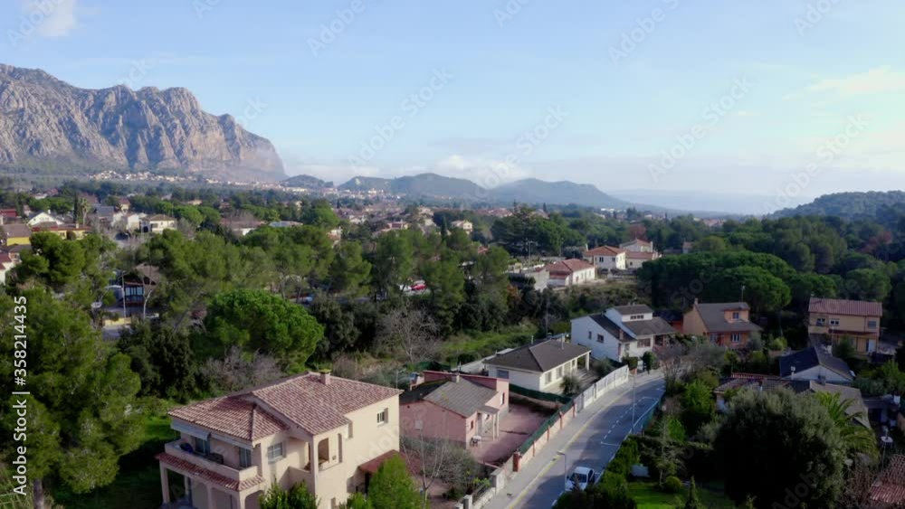 Aerial view descending toward street level in neighborhood with Montserrat in background on a sunny day - descending drone shot Aerial view descending toward street level in neighborhood with Montserrat in background on a sunny day - descending drone shot