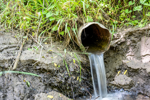 Fotografía Water flowing from the open outlet of a metal agriculture drainage tile