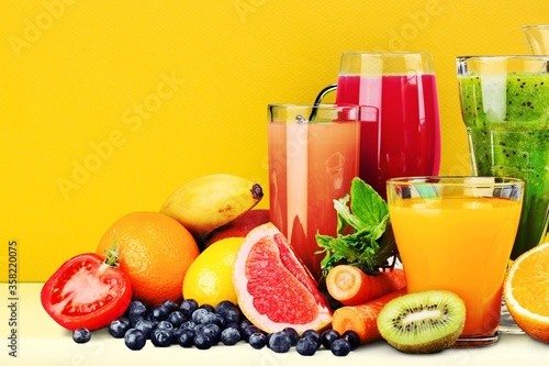 Fototapet Composition of fruits and glasses of juice on the desk