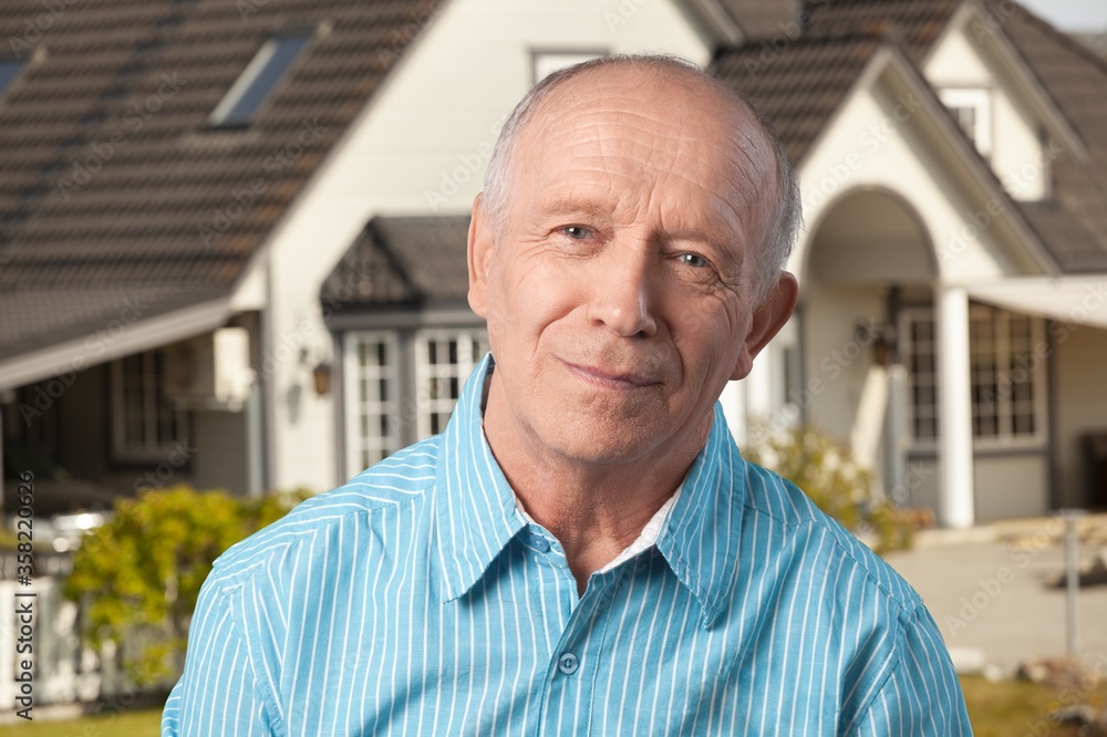 Handsome senior man standing on the house background Handsome senior man standing on the house background