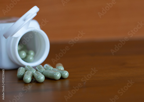 Herb capsule,Herble,Medicine and a bottle on wooden background. photo