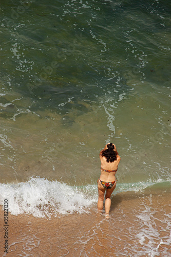 Fototapeta Naklejka Na Ścianę i Meble -  an undecided woman standing by the sea