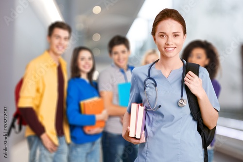 Attractive young female doctor with blurred hospital interior on background